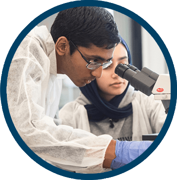 Students looking through a microscope in a laboratory